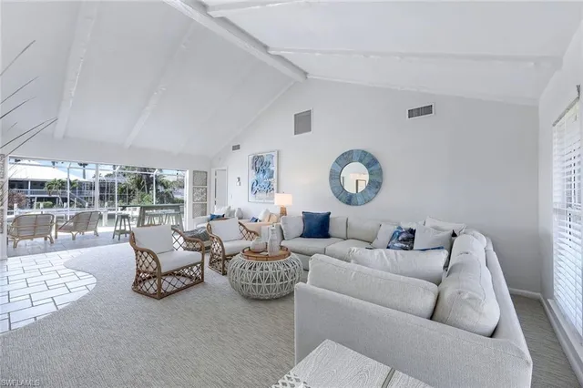 a living room with furniture a clock and a large window
