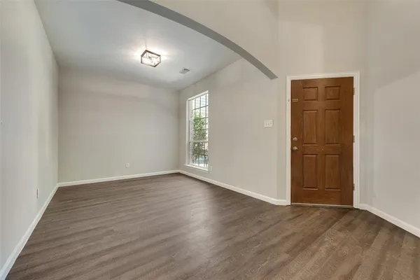 an empty room with wooden floor and closet area