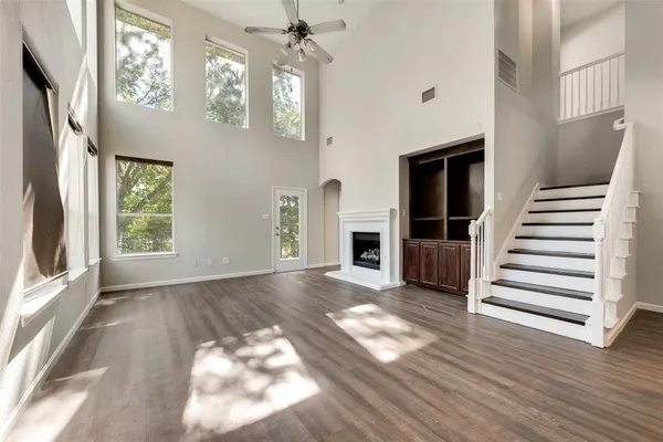 a view of a livingroom with wooden floor and staircase