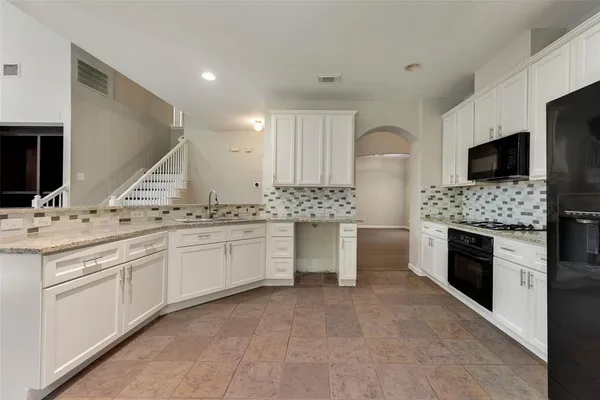 a large kitchen with a sink and a stove top oven