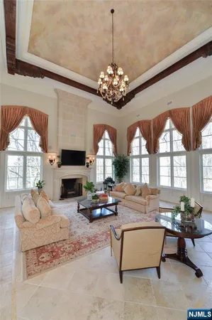 a living room with fireplace furniture a chandelier and a flat screen tv