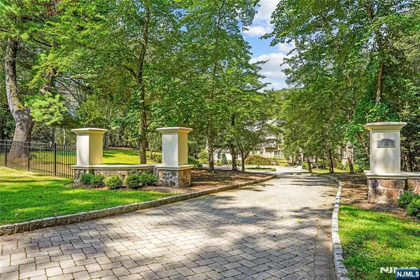 a view of a house with a big yard and large trees