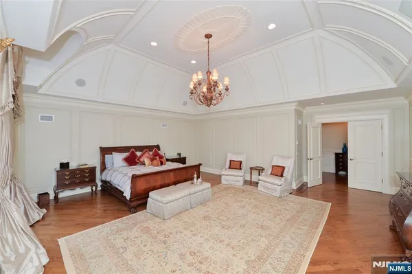 a bed room with a bed mirror and a chandelier