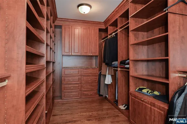 a view of walk in closet with clothes and shoes