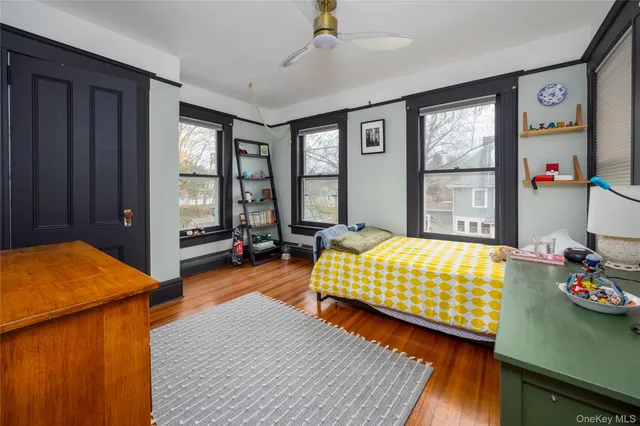 a bedroom with a bed and a dresser next to a window