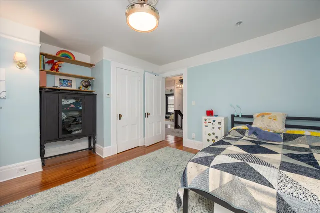 a bedroom with bed and wooden floor