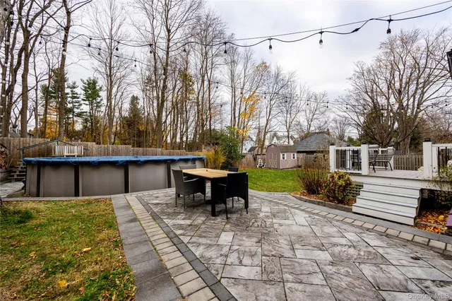 a view of a patio with table and chairs with wooden floor and fence