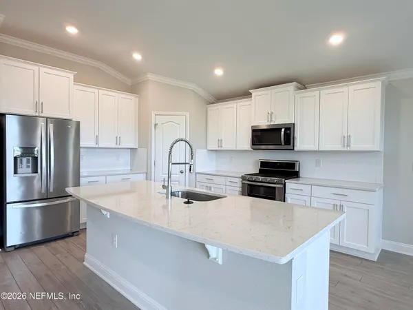 a kitchen with kitchen island a counter space a sink and appliances