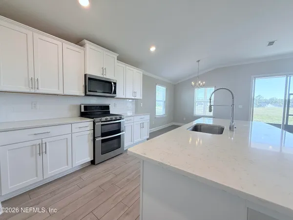 a kitchen with kitchen island a sink stainless steel appliances and cabinets
