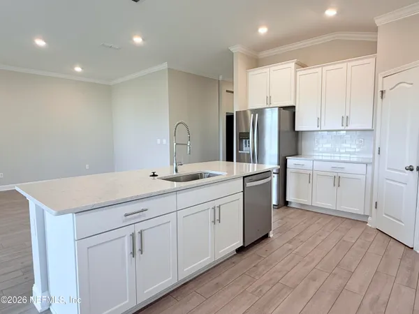 a kitchen with white cabinets white stainless steel appliances and sink