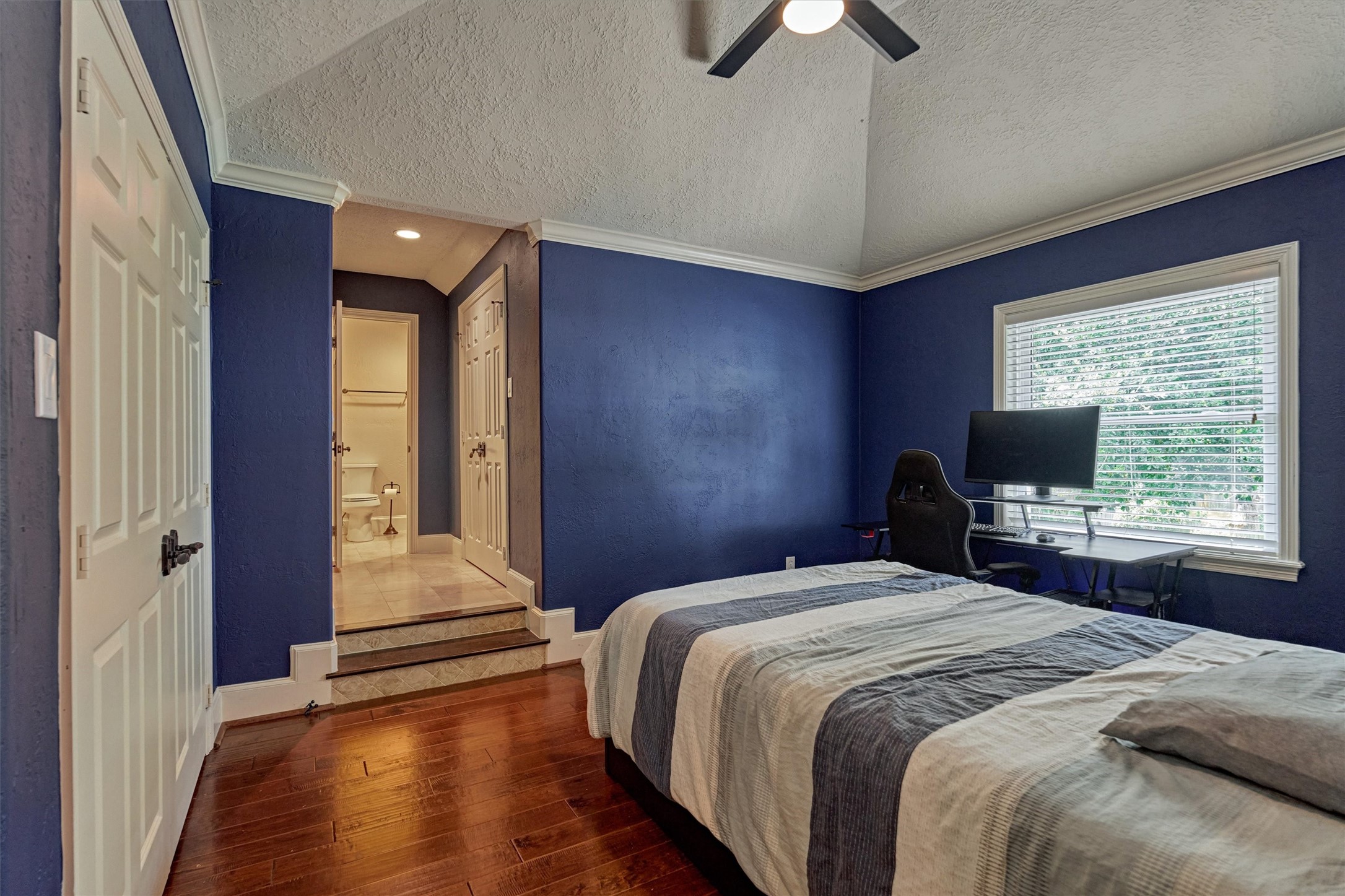 18 Treevine Court The Woodlands, TX 77381 - Photo 31 of 50 Secondary bedroom #2 is a spacious en suite featuring abundant closet space, soaring ceilings, and beautiful wood flooring.