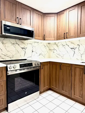 a view of kitchen with granite countertop white cabinets and stainless steel appliances