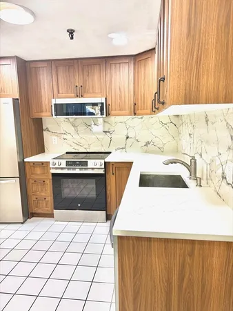 a kitchen with a stove a sink and a refrigerator