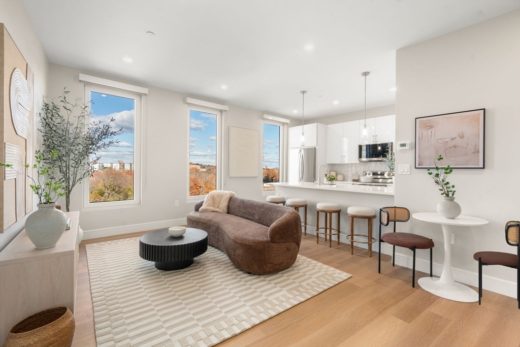40 Soldiers Field Place, Unit 301 Boston, MA 02135 - Photo 2 of 13 a living room with furniture and a large window