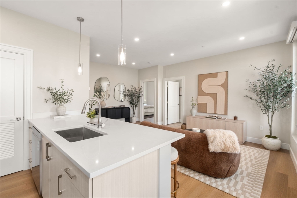 40 Soldiers Field Place, Unit 301 Boston, MA 02135 - Photo 4 of 13 a living room with furniture and a chandelier