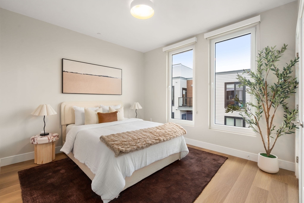 40 Soldiers Field Place, Unit 301 Boston, MA 02135 - Photo 7 of 13 a bedroom with a large bed and a potted plant