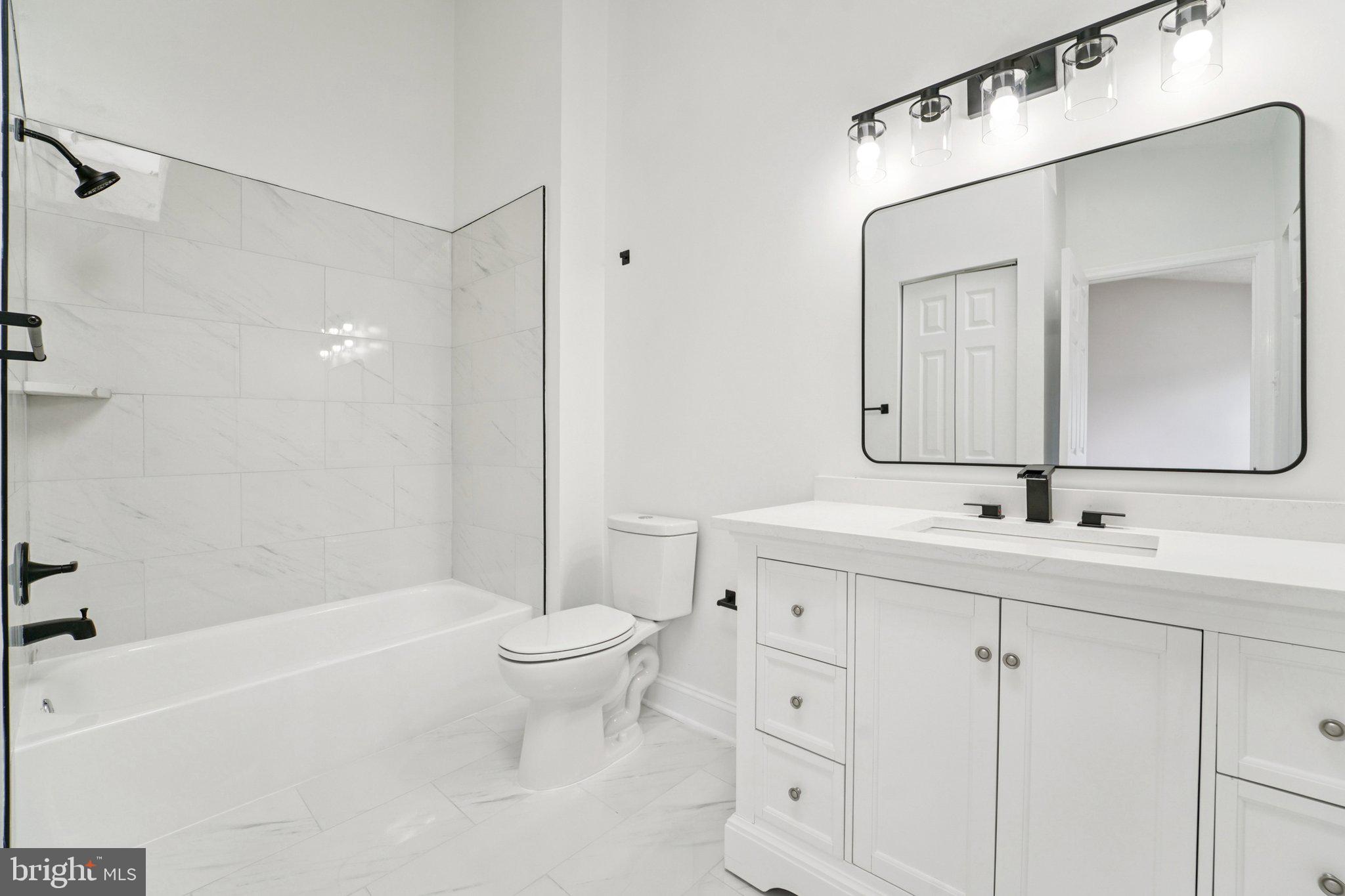 8727 Silver Hall Road Perry Hall, MD 21128 - Photo 15 of 35 a bathroom with a toilet a sink a mirror a bathtub and vanity