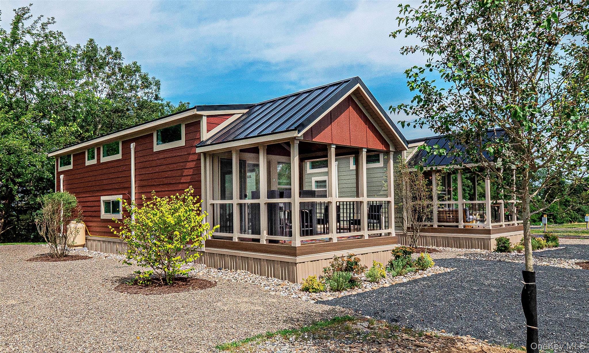 The Warwick Model. View of home's exterior with a metal roof, a standing seam roof, and covered porch