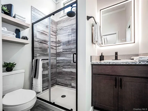 a bathroom with a granite countertop sink toilet and shower