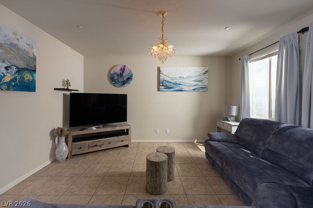 3069 Scenic Rhyme Avenue Henderson, NV 89044 - Photo 9 of 29 The living room completes the open-concept main level with a statement crystal chandelier, a large side window for natural light, and enough floor space for a true family room setup without crowding.