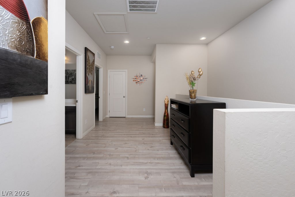3069 Scenic Rhyme Avenue Henderson, NV 89044 - Photo 11 of 29 The upstairs landing sets the tone for the second floor: wide-plank LVP flooring throughout, multiple bedroom and bathroom doors off a spacious hallway, recessed lighting, and an open railing overlooking the entry below.
