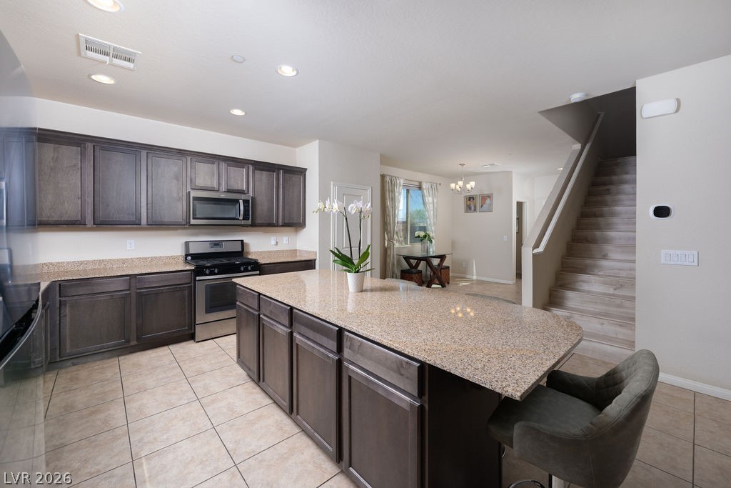 3069 Scenic Rhyme Avenue Henderson, NV 89044 - Photo 27 of 29 From the island, the floor plan opens toward the dining nook and staircase beyond — a layout that makes spatial sense the moment you walk in. The kitchen is the center of this home, and this angle proves it.