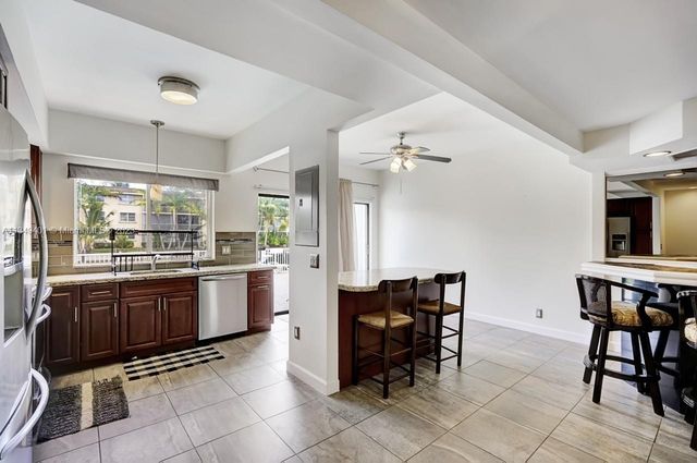 a kitchen with stainless steel appliances granite countertop a table and chairs in it