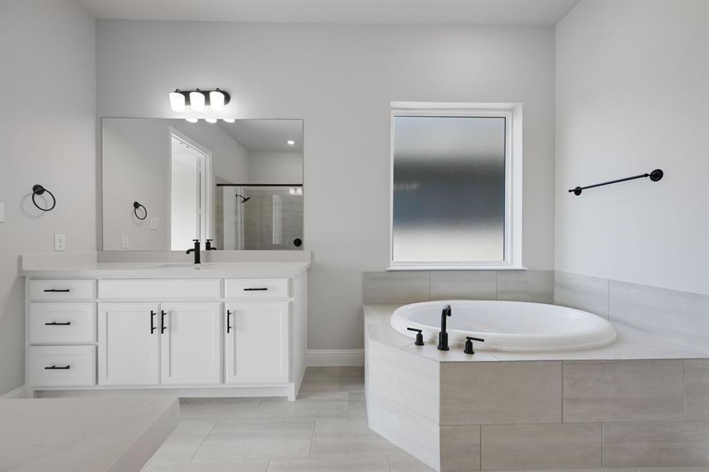 1612 Yellow Rose Road Celina, TX 75009 - Photo 14 of 40 a spacious bathroom with a tub a double vanity sink a mirror a lamp and bathtub