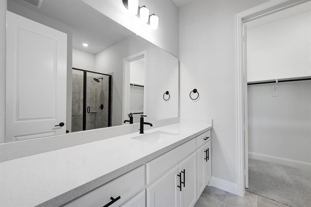 1612 Yellow Rose Road Celina, TX 75009 - Photo 15 of 40 a bathroom with a sink and a mirror