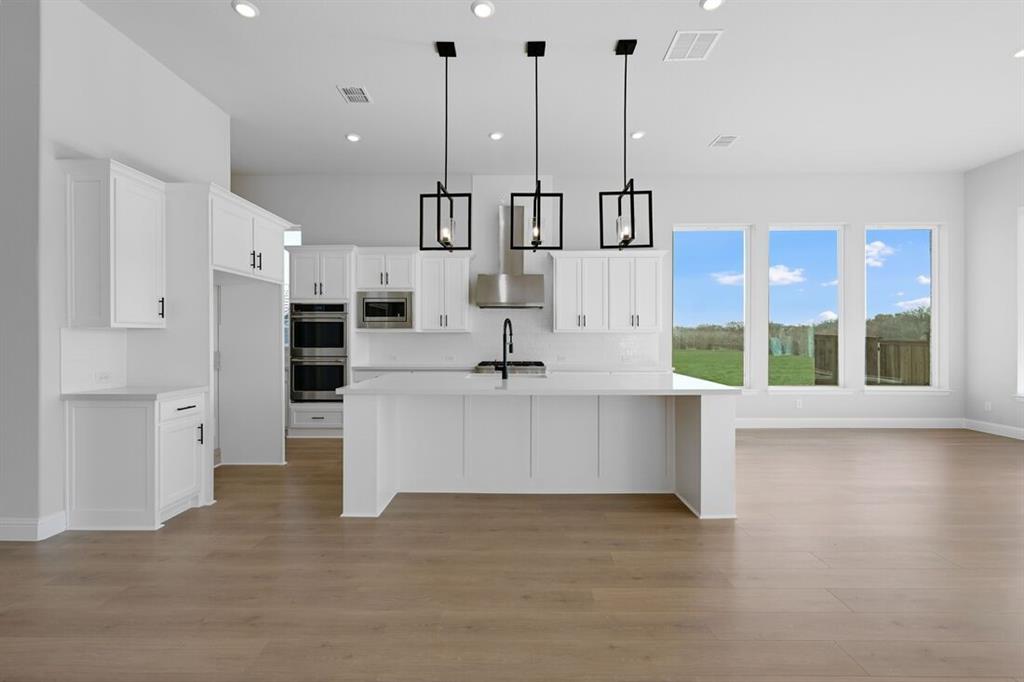 1612 Yellow Rose Road Celina, TX 75009 - Photo 2 of 40 a view of kitchen with stainless steel appliances kitchen island granite countertop a refrigerator a stove a oven and a sink with granite countertops