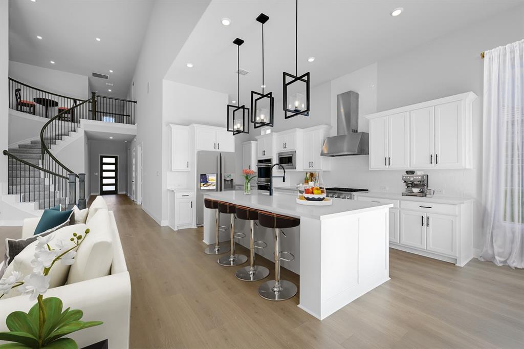 1612 Yellow Rose Road Celina, TX 75009 - Photo 4 of 40 a kitchen with stainless steel appliances kitchen island granite countertop a sink a stove and a wooden floors