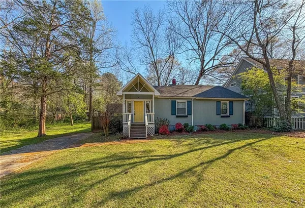 a view of a house with a yard patio and a tree