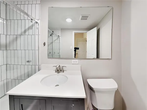a bathroom with a sink a toilet and mirror