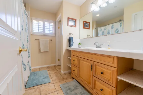 a spacious bathroom with a sink a mirror and a shower