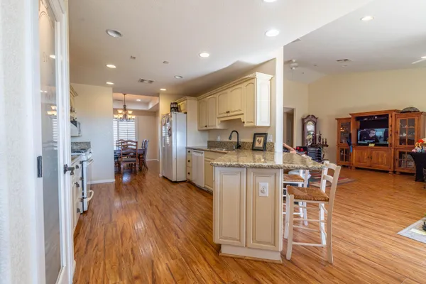 a kitchen with stainless steel appliances kitchen island wooden floors and white cabinets