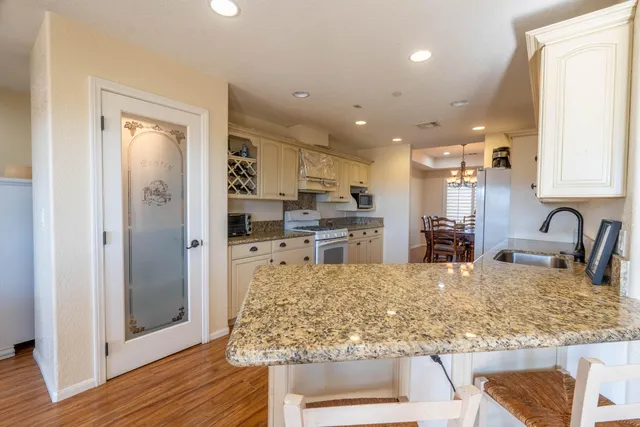 a kitchen with stainless steel appliances granite countertop a sink stove and refrigerator