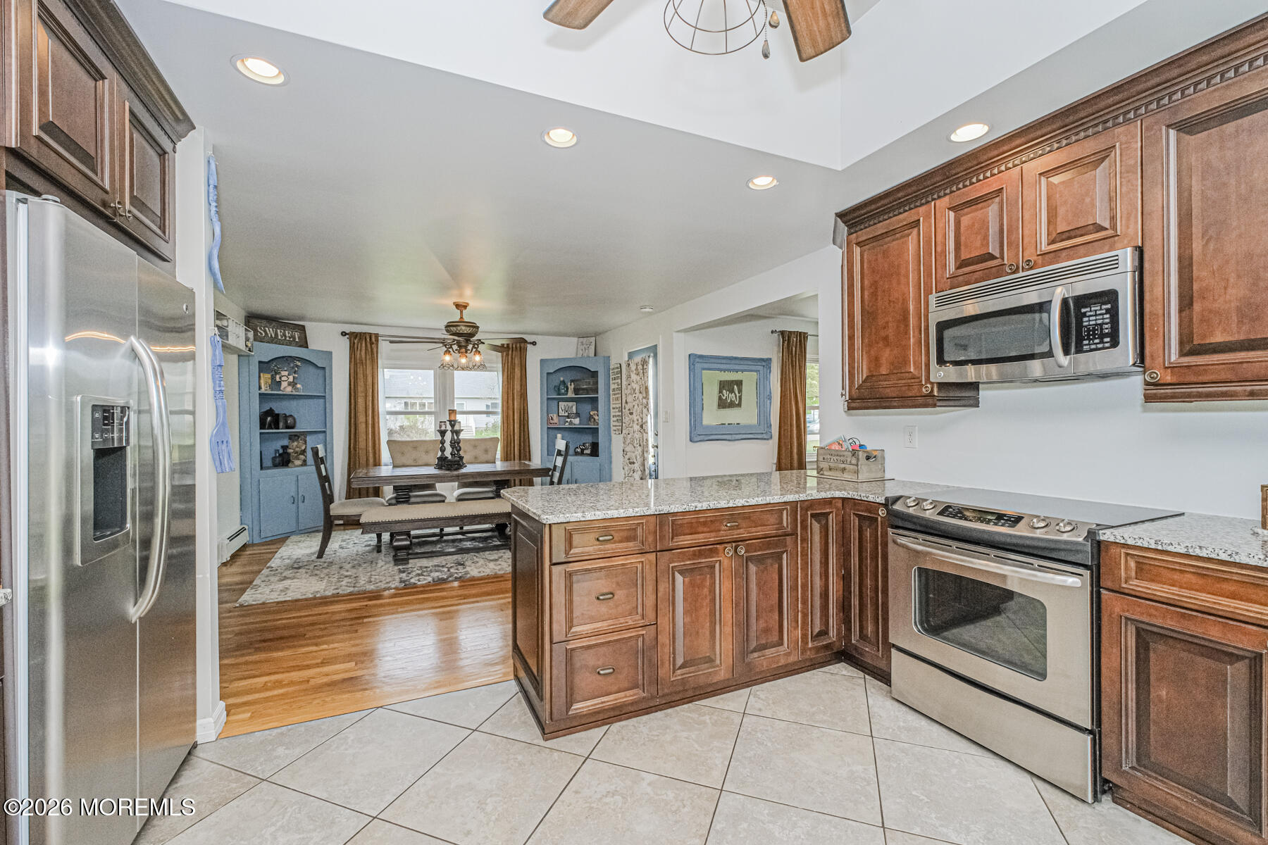 5 Riccis Drive Jackson, NJ 08527 - Photo 14 of 32 a kitchen with stainless steel appliances granite countertop a stove top oven a sink dishwasher a dining table and chairs with wooden floor