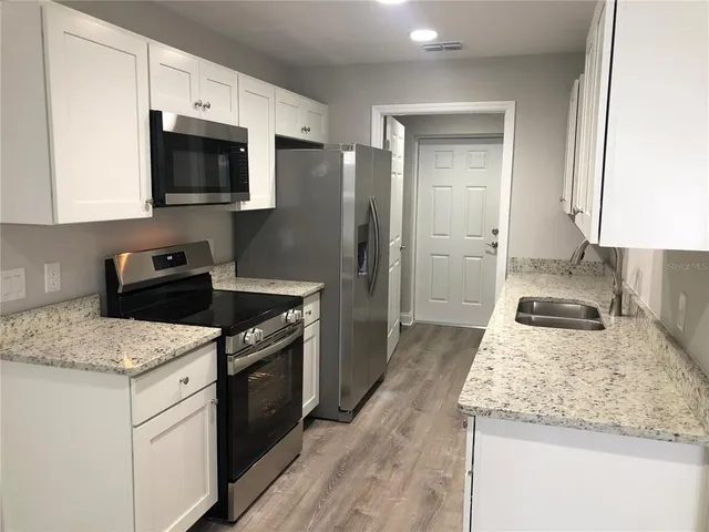 a kitchen with a sink stove and microwave