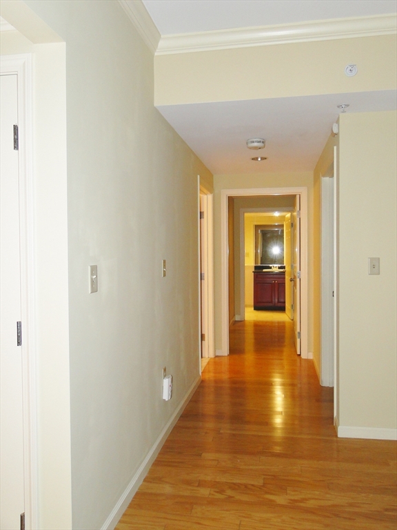 1 Nassau Street, Unit 1607 Boston, MA 02111 - Photo 8 of 17 a view of a hallway with wooden floor