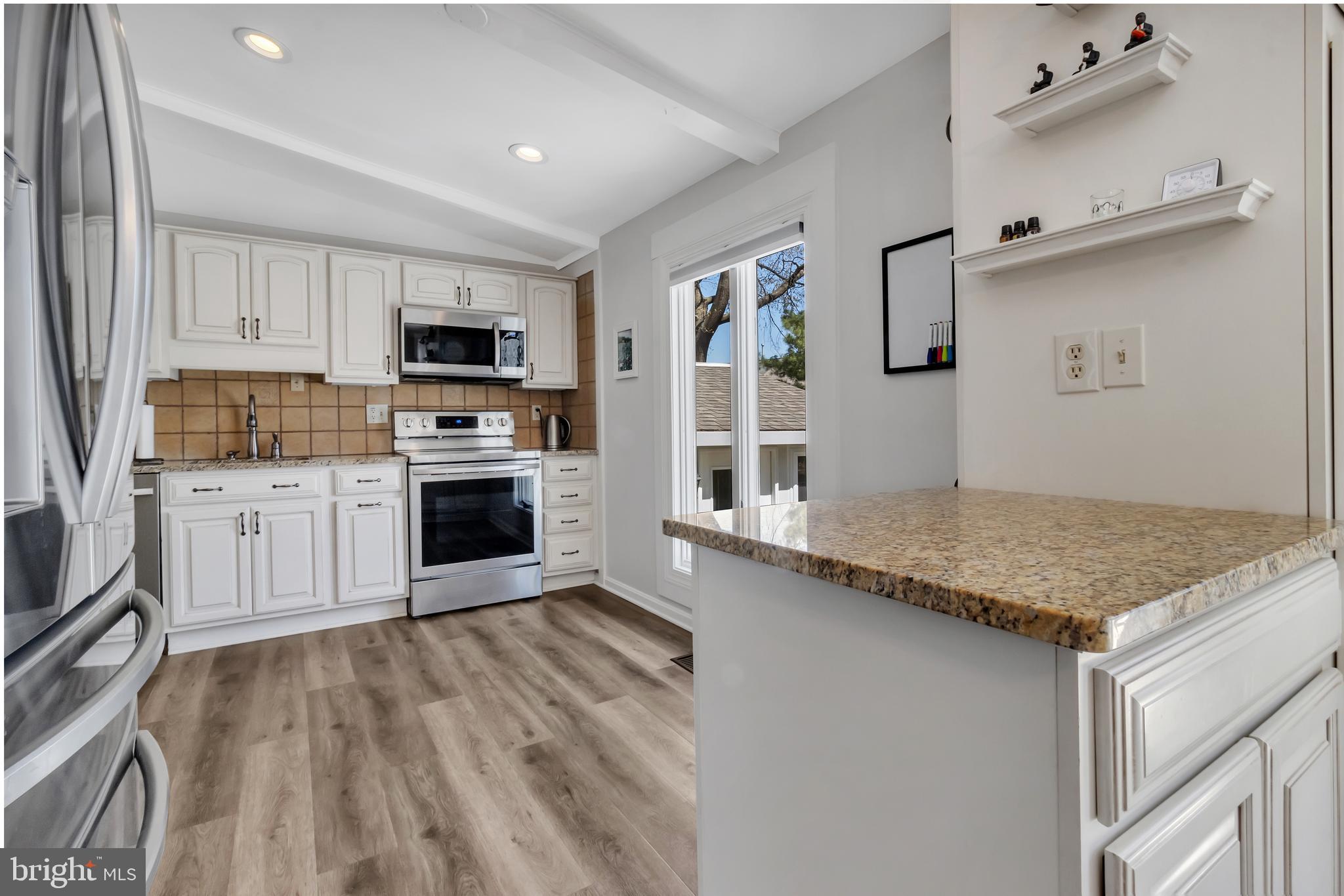 607 Bay Green Drive Arnold, MD 21012 - Photo 19 of 52 a kitchen with stainless steel appliances granite countertop a stove top oven a sink dishwasher and a refrigerator with wooden floor