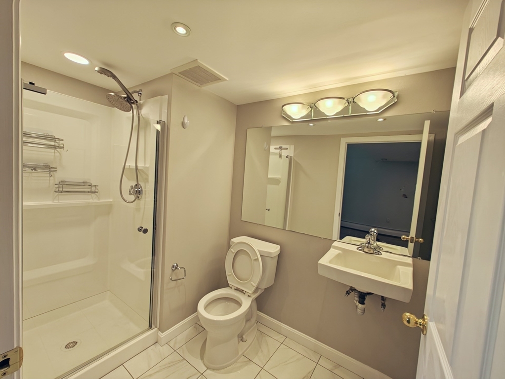 548 Worcester Street Natick, MA 01760 - Photo 18 of 21 a bathroom with a sink toilet a mirror and shower