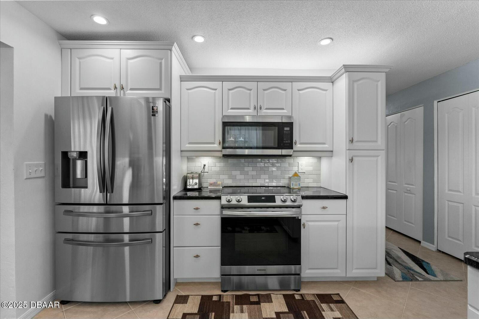 1 Cobblestone Trail Ormond Beach, FL 32174 - Photo 16 of 31 a kitchen with stainless steel appliances granite countertop a refrigerator stove and microwave