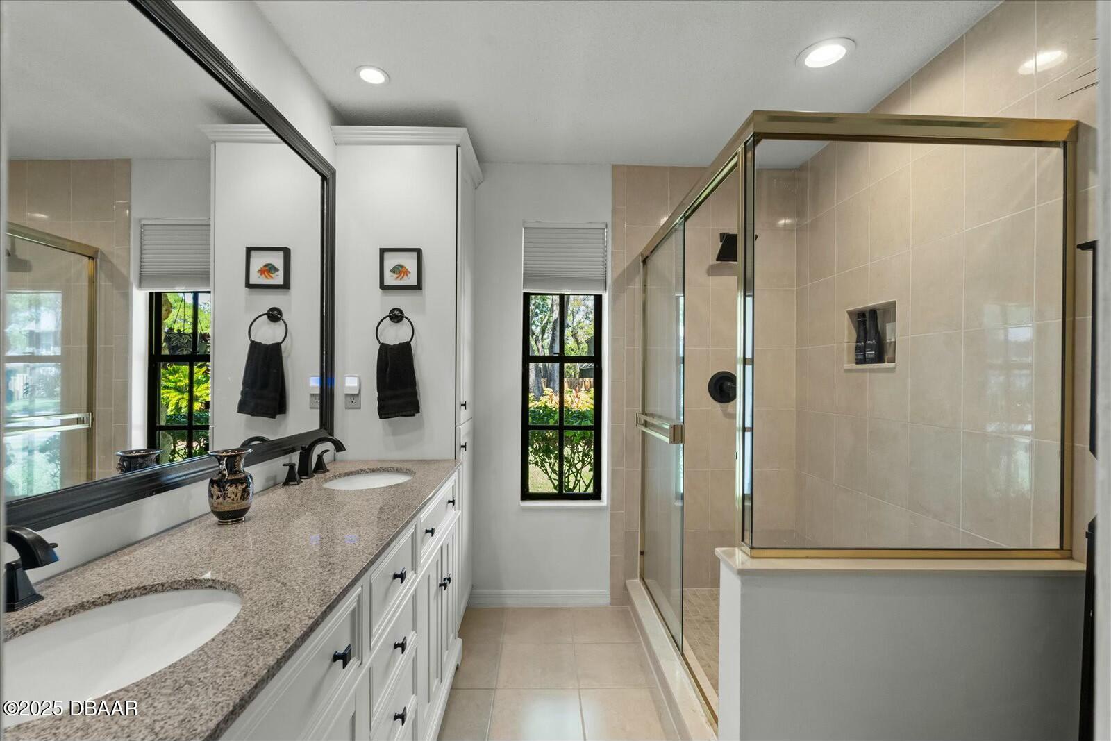 1 Cobblestone Trail Ormond Beach, FL 32174 - Photo 23 of 31 a bathroom with a granite countertop sink a mirror a shower and a bathtub