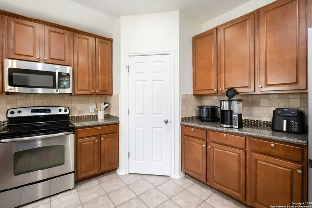 a kitchen with stainless steel appliances granite countertop a stove a sink and a microwave