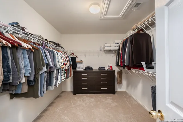 a view of walk in closet with clothes and shoes