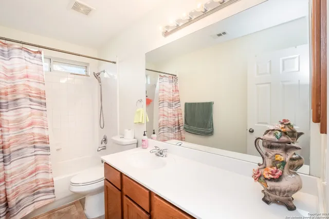 a bathroom with a sink vanity mirror and toilet
