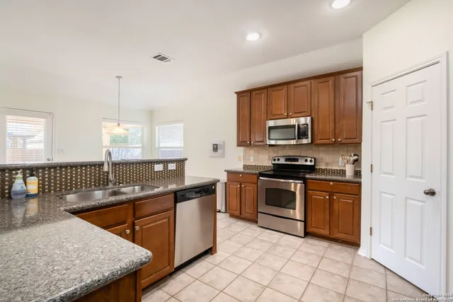 a kitchen with stainless steel appliances granite countertop a sink stove and microwave