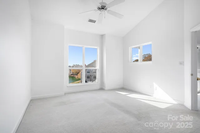 an empty room with a fireplace and windows