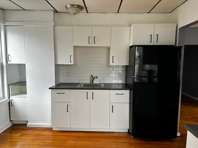 a kitchen with granite countertop a refrigerator and a sink