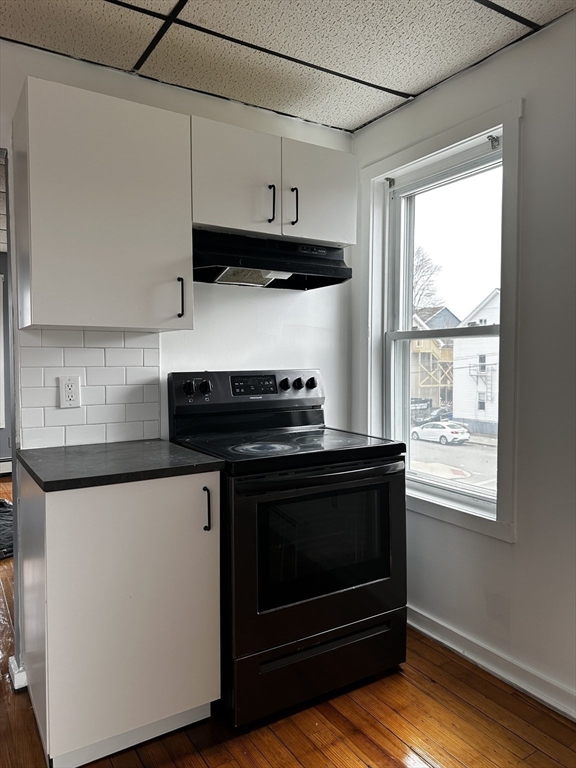 189 5th Street, Unit 2 Fall River, MA 02721 - Photo 3 of 18 a kitchen with stainless steel appliances a stove a microwave and wooden cabinets